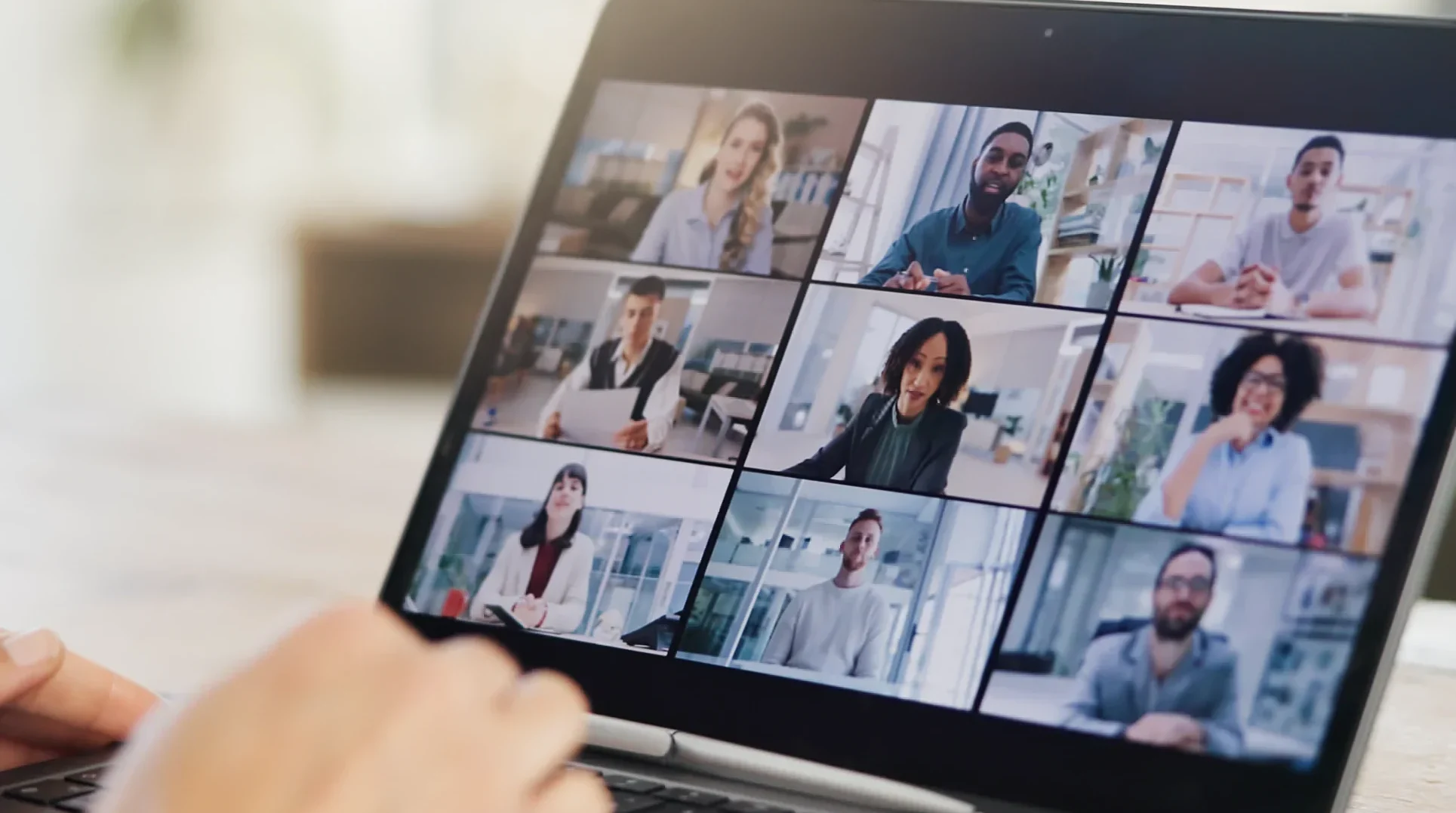A laptop with a video call with multiple people.