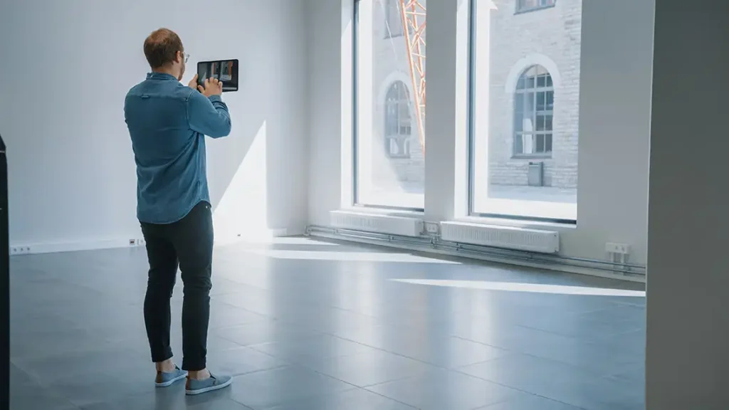 young professional is Mobile 3D Building scanning an empty room with iPad
