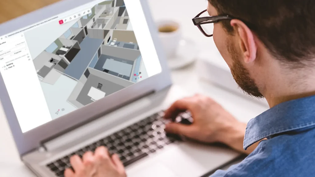 a 35 years old man is checking a 3D model in the Metaroom Workspace on his laptop.